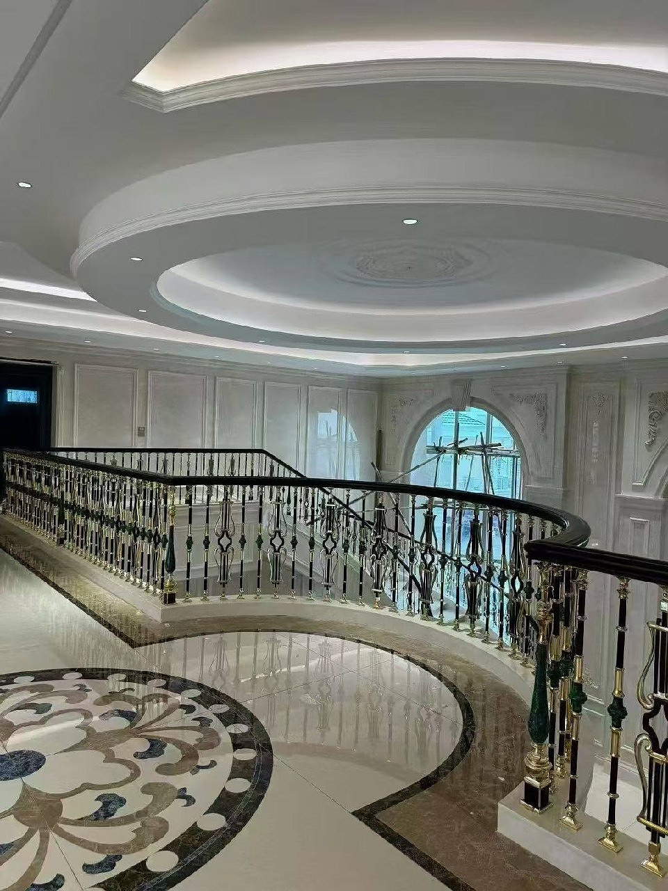 CHIFU Spiraltreppe mit schwarz-gold-grünen Geländerpfosten in repräsentativer Villa mit Marmor-Mosaik-Boden
